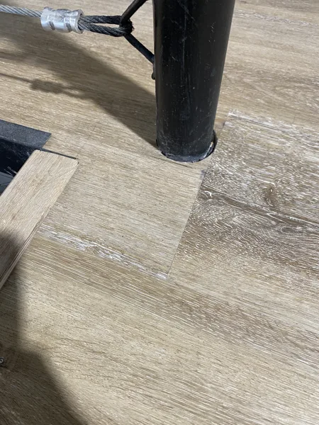 A closer angle of the fitted plank edges surrounding the railing post.