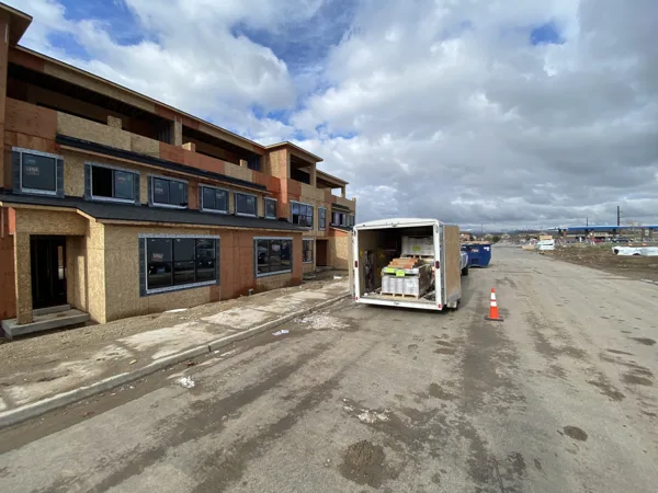 A trailer and construction access beside the community buildings.