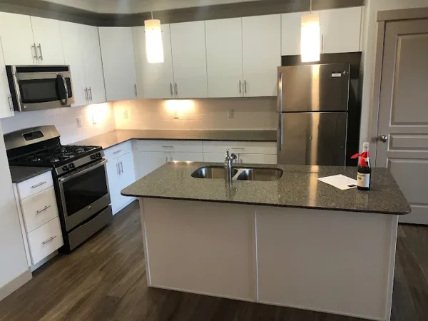 A finished kitchen with island, appliances and flooring.