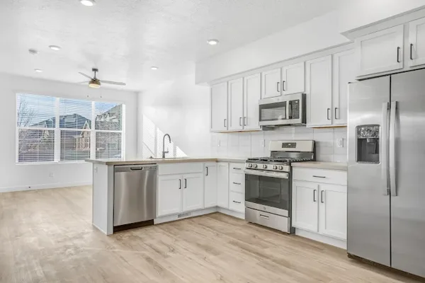 Kitchen cabinetry, island and flooring in a finished interior.
