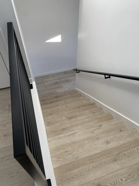 Laminate at the stair landing alongside the railing.