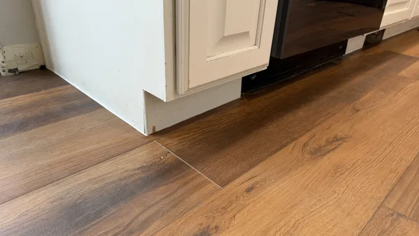 A close view of the flooring edge at the kitchen cabinetry. Product-specific expansion requirements must be reviewed for each installation.