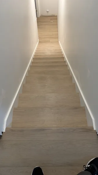 Each tread is fitted to the surrounding walls, creating a crisp line through this narrow stairwell.