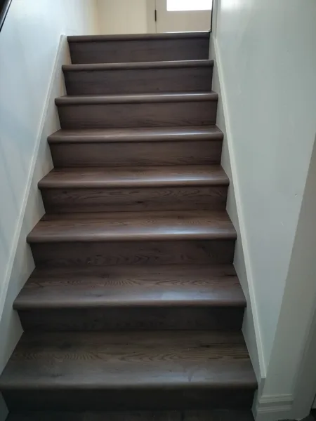 Carefully fitted treads follow the staircase, with clean edges along each side and a consistent finish from bottom to top.